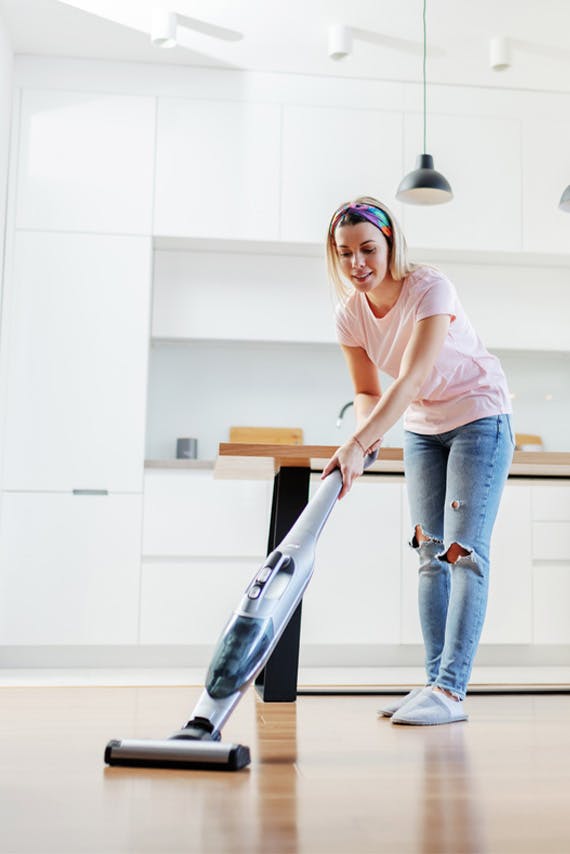 woman vacuuming kitchen floor